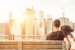 couple relaxing on New york bench in front of the skyline at sun